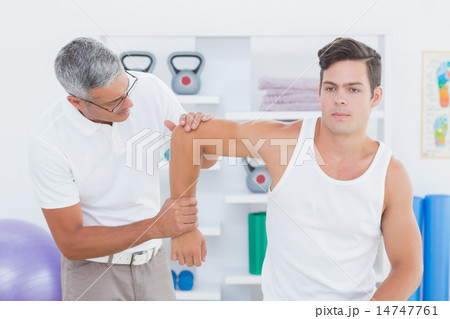 Doctor stretching a young man arm 14747761