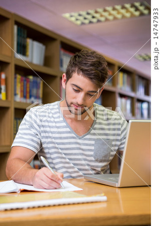 Student studying in the library with laptop Student studying in the library with laptop 14747933