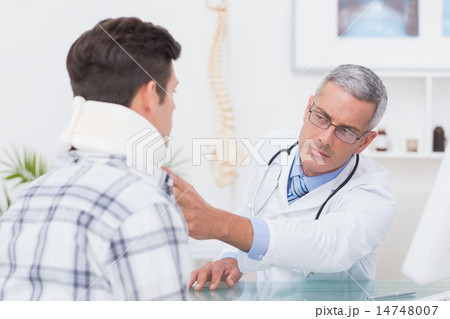 Doctor examining patient wearing neck brace Doctor examining patient wearing neck brace 14748007