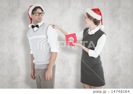 Composite image of geeky hipster offering present to her boyfrie Composite image of geeky hipster offering present to her boyfrie 14748164