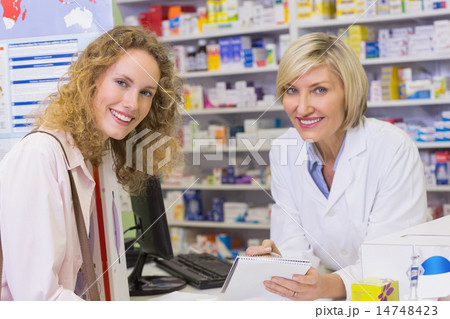 Pharmacist and costumer looking at camera Pharmacist and costumer looking at camera 14748423