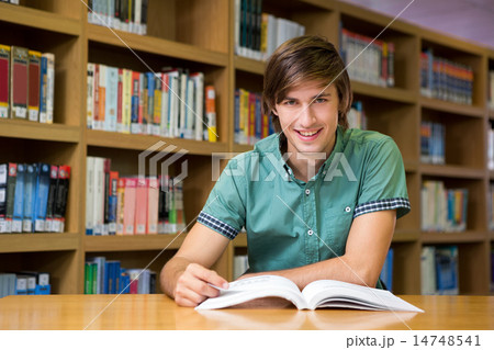 Student sitting in library reading 14748541