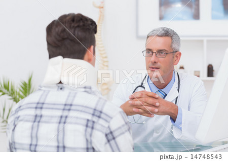 Doctor talking to patient wearing neck brace 14748543