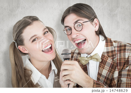 Composite image of happy geeky hipsters singing with microphone 14748629