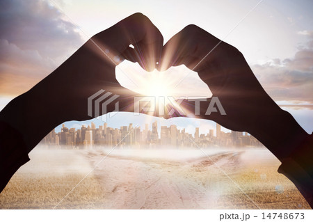 Composite image of woman making heart shape with hands 14748673
