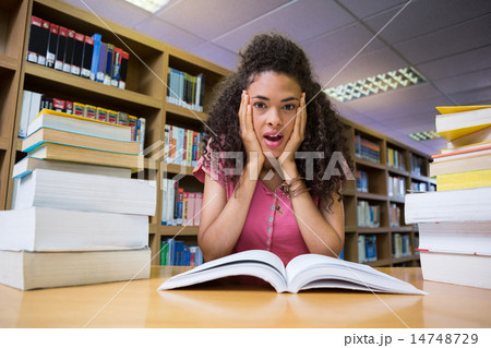 Pretty student studying in the library 14748729
