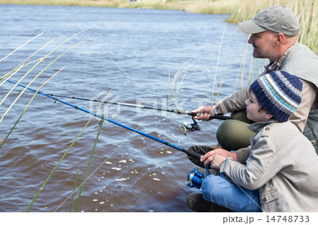 Father and son fishing at a lake Father and son fishing at a lake 14748733