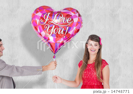 Composite image of geeky hipster offering red heart shape balloo 14748771