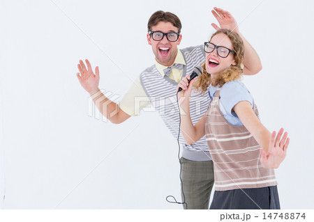 Geeky hipster couple singing into a microphone Geeky hipster couple singing into a microphone 14748874