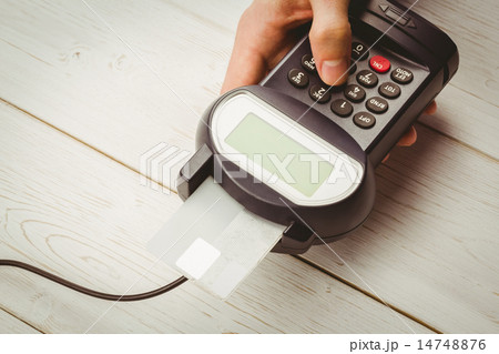 Man entering his pin on terminal 14748876