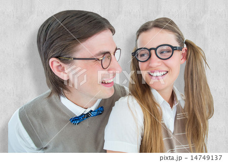 Composite image of geeky hipster couple smiling at each other Composite image of geeky hipster couple smiling at each other 14749137