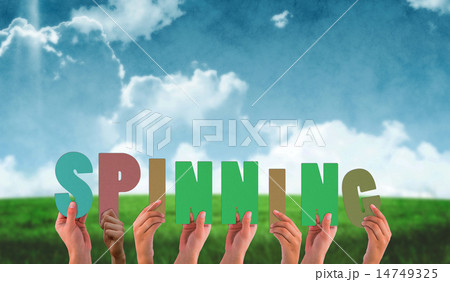 Composite image of hands holding up spinning 14749325
