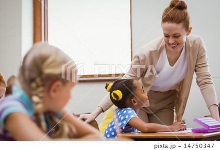 Teacher helping a little girl during class Teacher helping a little girl during class 14750347