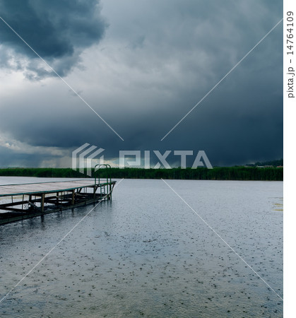 drops of rain on river under dark clouds 14764109