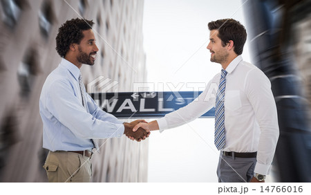 Composite image of smiling young businessmen shaking hands in of Composite image of smiling young businessmen shaking hands in of 14766016