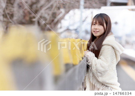 無人駅のホームで電車を待つ若い女性 14766334