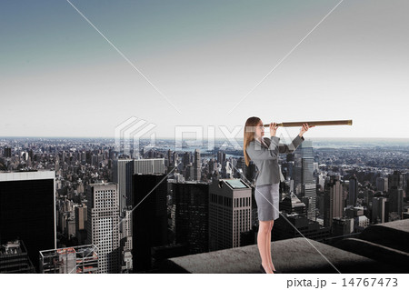 Composite image of businesswoman looking through a telescope 14767473