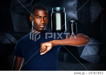 Composite image of fit man holding bottles with supplements on h 14767852