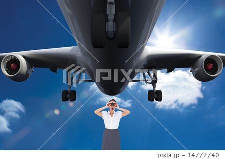 Composite image of shocked elegant businesswoman looking through binoculars 14772740