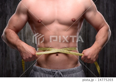 Close up of well formed man measuring his waist 14775203