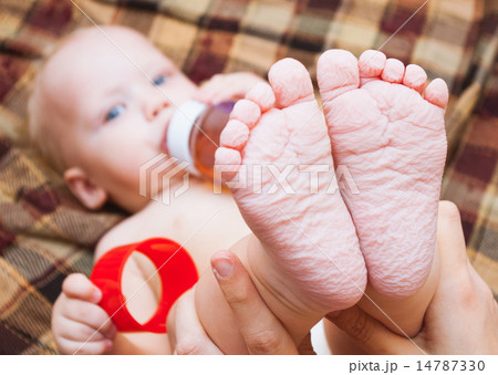 little baby drinking tea or juice from bottle 14787330