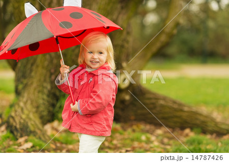 Portrait of smiling baby with red umbrella outdoors 14787426