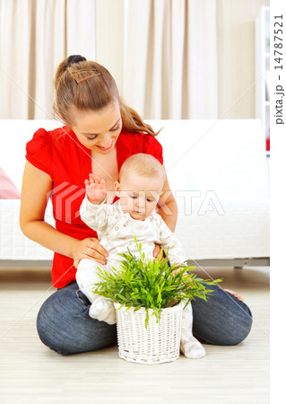 Smiling mommy showing plant to her baby Smiling mommy showing plant to her baby 14787521