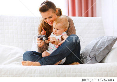 Young mom showing her interested baby photos on camera Young mom showing her interested baby photos on camera 14787603