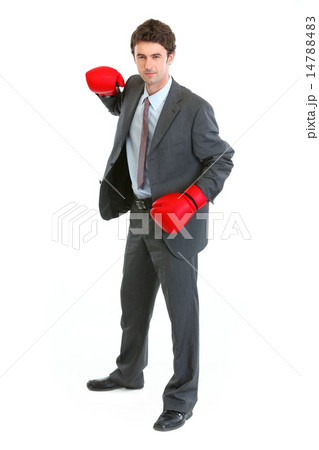 Businessman in boxing gloves swinging arm to strike 14788483
