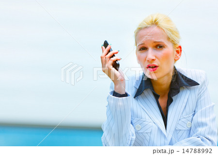 Outraged business woman with cell phone leaning on railing at of Outraged business woman with cell phone leaning on railing at of 14788992