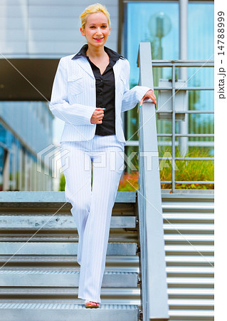 Smiling business woman walking down stairs 14788999