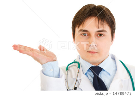 Serious doctor presenting something on empty hand. Serious doctor presenting something on empty hand. 14789475