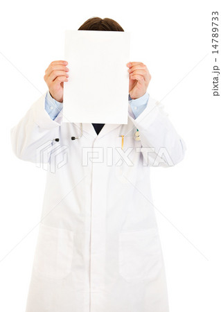 Doctor holding empty white paper in front of her face. Doctor holding empty white paper in front of her face. 14789733