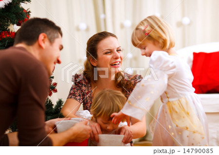 Mom and dad looking with twins daughters inside of Christmas soc 14790085
