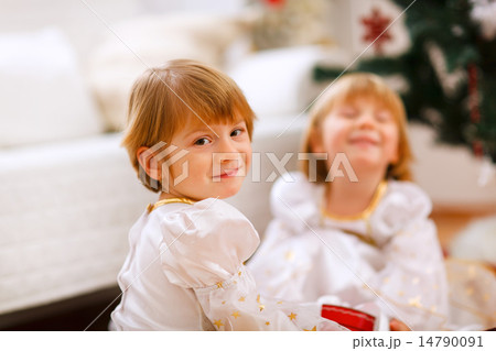 Portrait of happy girl playing with sister near Christmas tree 14790091