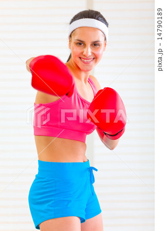 Smiling fitness girl in boxing gloves punching 14790189