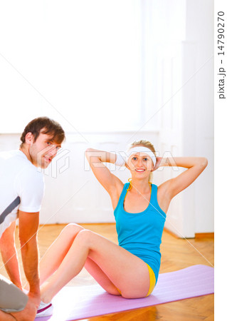 Smiling fit girl making abdominal crunch Smiling fit girl making abdominal crunch 14790270