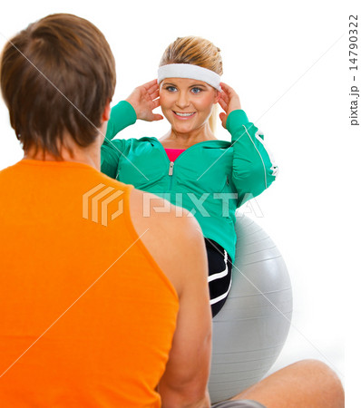 Personal sport trainer helping healthy girl making abdominal cru Personal sport trainer helping healthy girl making abdominal cru 14790322