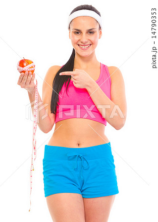 Smiling young fit girl pointing finger on apple with measuring tape. 14790353