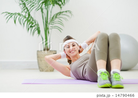 Happy healthy woman doing abdominal crunch Happy healthy woman doing abdominal crunch 14790466