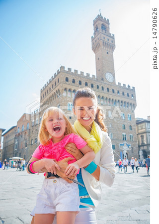 Portrait of smiling mother and baby girl in front of palazzo vec 14790626