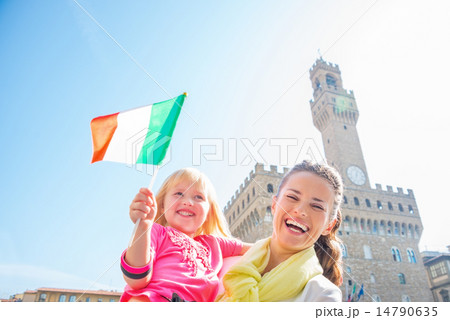 Portrait of happy mother and baby girl with flag in front of pal Portrait of happy mother and baby girl with flag in front of pal 14790635