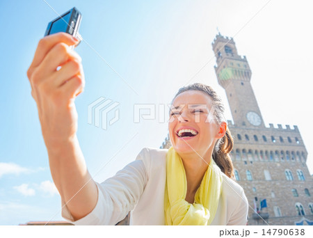 Happy young woman making selfie in front of palazzo vecchio in f Happy young woman making selfie in front of palazzo vecchio in f 14790638
