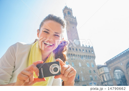 Happy young woman with photo camera in front of palazzo vecchio 14790662
