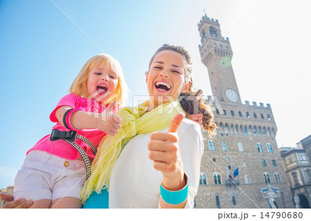 Happy mother and baby girl showing thumbs up in front of palazzo Happy mother and baby girl showing thumbs up in front of palazzo 14790680