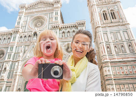 Happy mother and baby girl taking photo in front of duomo in flo 14790850