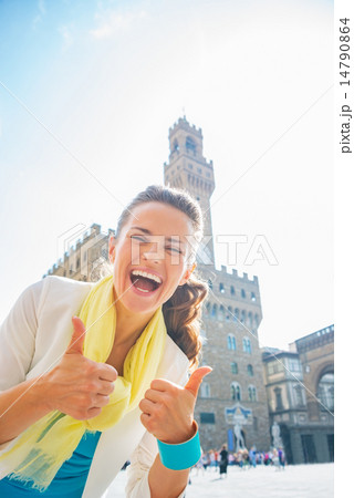Happy young woman showing thumbs up in front of palazzo vecchio Happy young woman showing thumbs up in front of palazzo vecchio 14790864
