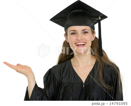 Smiling graduation student girl showing something on empty hand 14791095