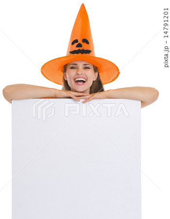 Smiling woman in Halloween hat with blank billboard Smiling woman in Halloween hat with blank billboard 14791201