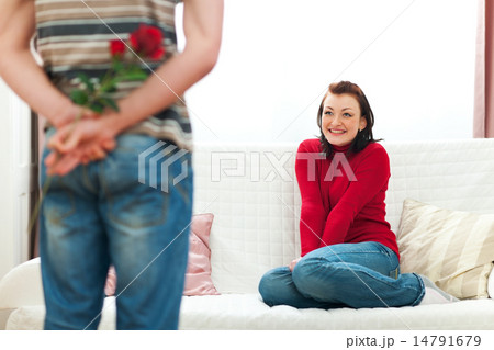 Guy hiding red rose to make surprise to girlfriend 14791679